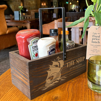 a wooden box filled with condiments on top of a wooden table