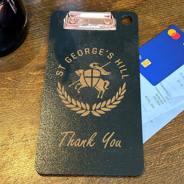 a black luggage tag sitting on top of a wooden table