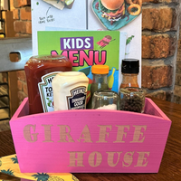 a pink box filled with food sitting on top of a wooden table