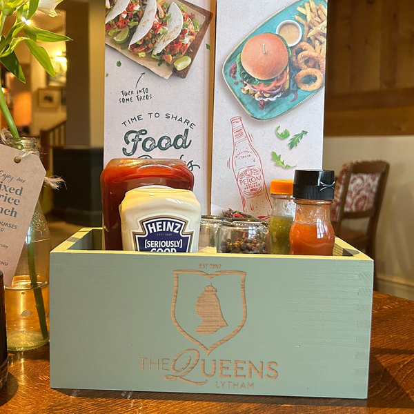 a wooden table topped with a box filled with food